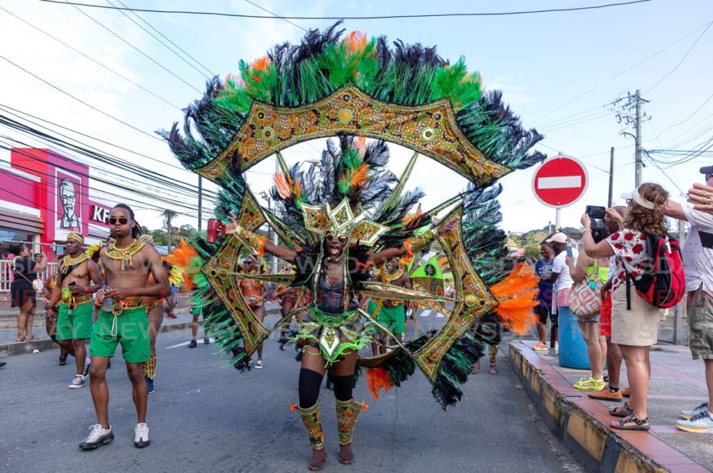 A masquerader from Gloria Stoiute Creation portrays her costume during the parade of the bands along Milford Road, Scarborough, Carnival Tuesday. - Photo by David Reid