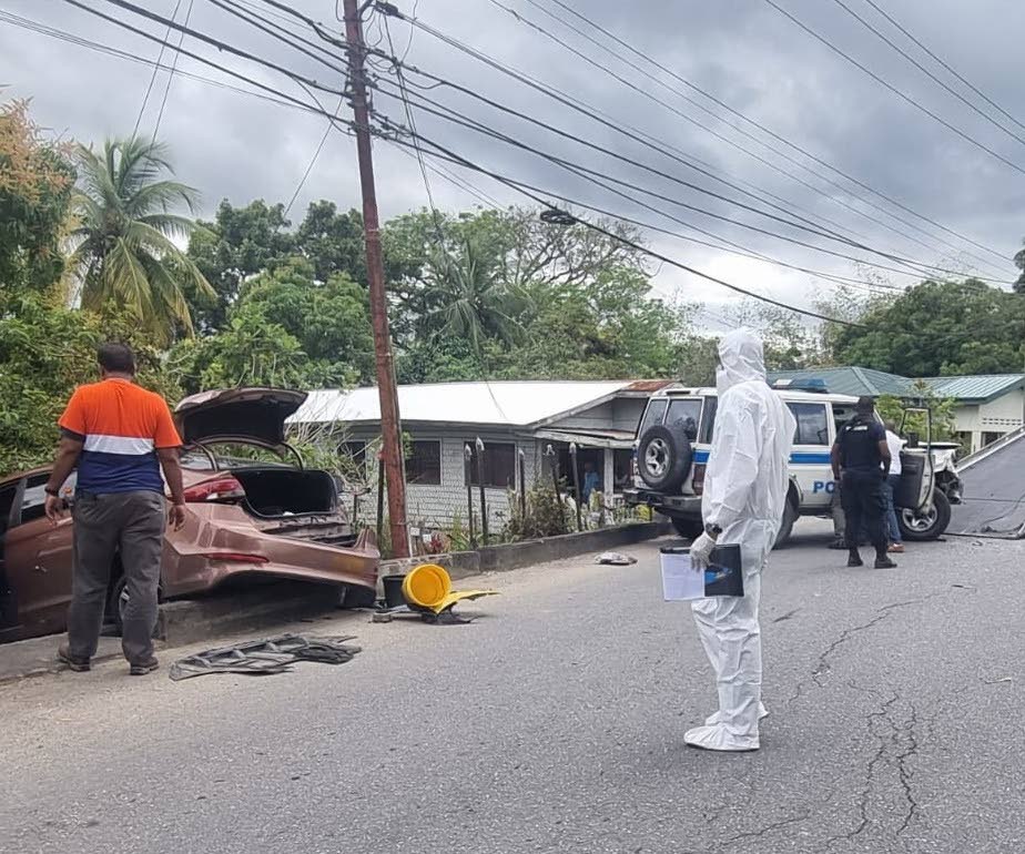 WRECKED: In this uncredited photo, crime scene investigators are at the site of a police-involved killing in which one suspect was shot dead and two others wounded during a confrontation with police at Cleghorn Village, Princes Town on Friday morning. - 