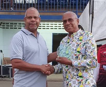 NAAA president George Comissiong, left, gives an award to 1966 double gold medallist (individual 440 yards and 4x440 yards relay) Wendell Mottley. - 