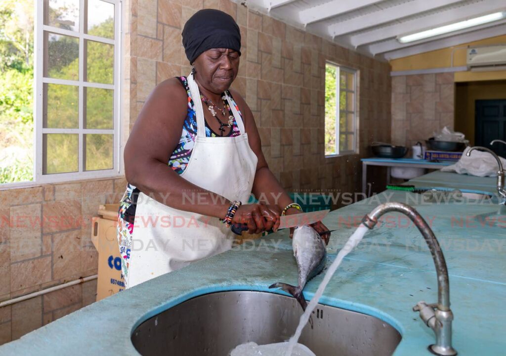 Fish vendor Amy McMillan prepares a fresh catch of Bonito for a customer at Pigeon Point Fish Market on Tuesday. - Photo by David Reid