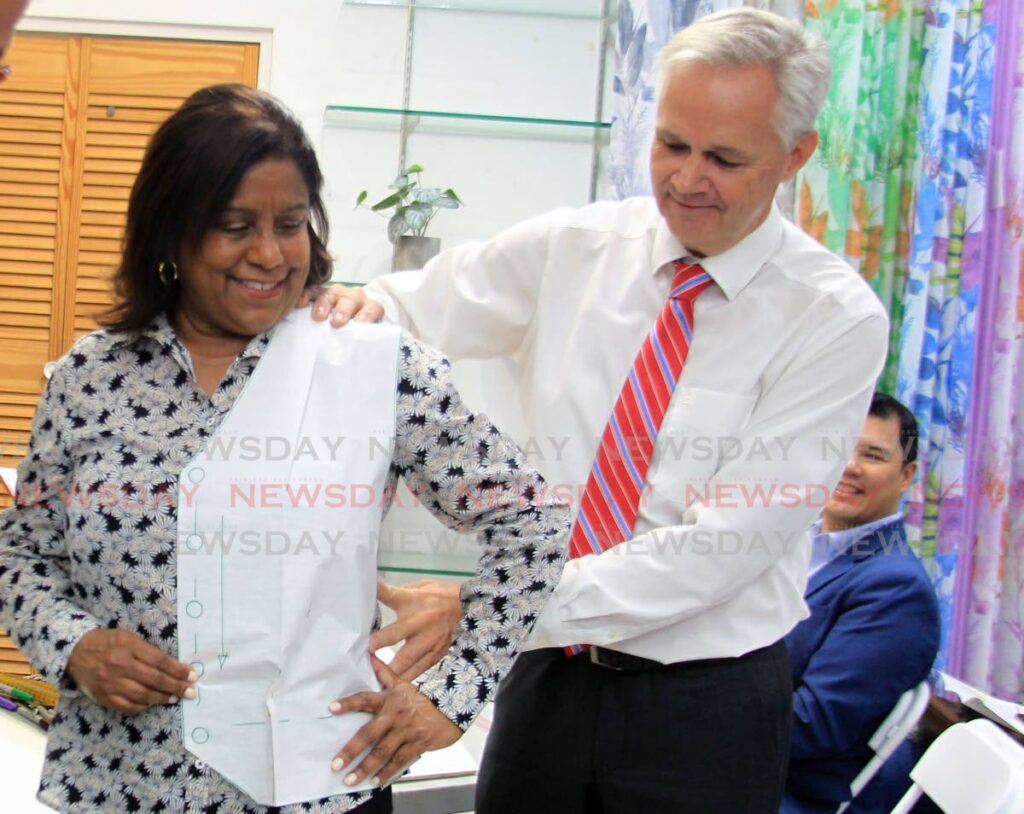 FASHION FIT: President of Fashion Unlimted Inc, Frank Lutterloh measures a pattern on Trade and Industry Minister Paula Gopee-Scoon during a dress-making class on Wednesday at the Jimmy Aboud textile store on Henry Street in Port of Spain. PHOTO BY AYANNA KINSALE - 