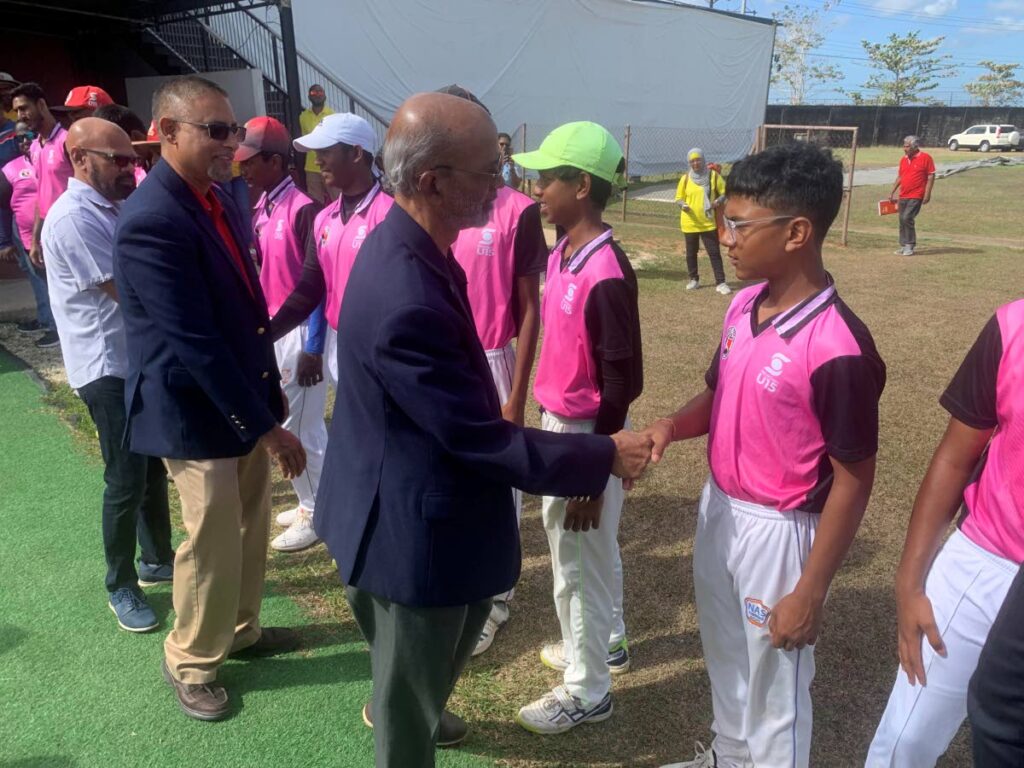 First vice-president of the TTCB Arjoon Ramlal greets Ishant  Roopnarine of the East Zone Under-15 team before the Inter Zone final against Central. The other TTCB officials behind Ramlal are Altaf Baksh (general secretary) and Kiswah Chaitoo (treasurer). - 