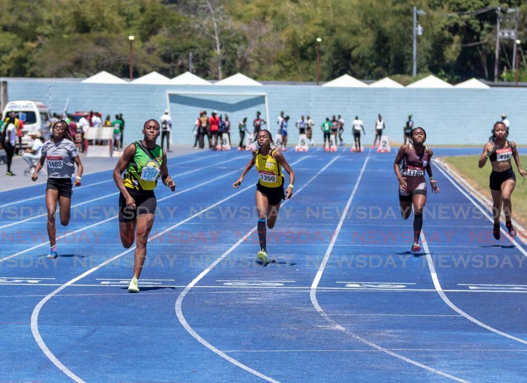 Signal Hill Secondary’s Alexxe Henry (2nd left) races to the finish line to win the girls U-17 100m, at National Secondary School Track and Field Championship, on Wednesday, at the Dwight Yorle Stadium, Bacelot. - David Reid