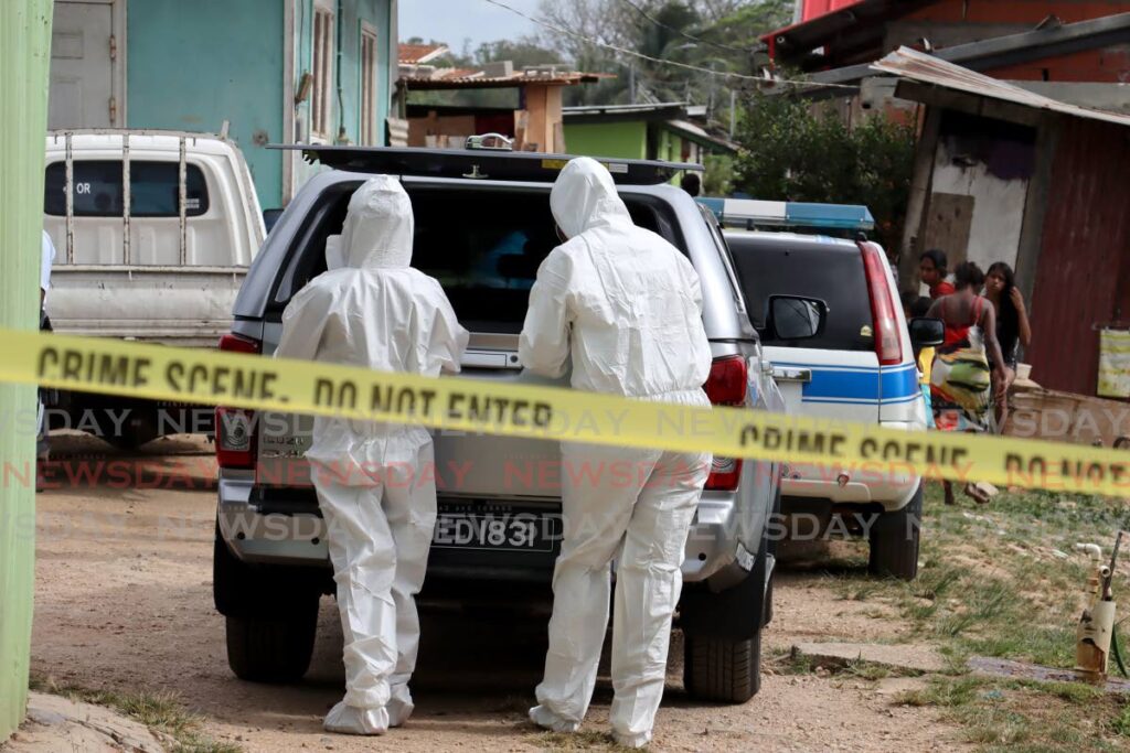 Crime scene investigators gather evidence after the murder of Aneesa Ramkissoon at her St Augustine South home on February 3.  - File photo/ROGER JACOB
