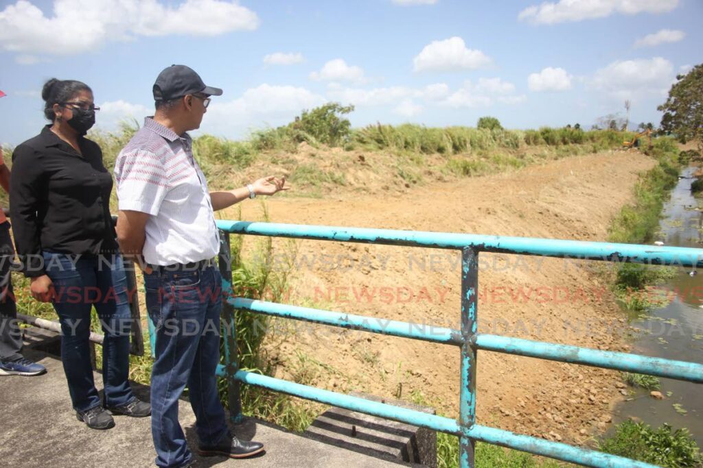 Minister of Works and Transport Rohan Sinanan and acting director of drainage Katherine Badloo-Doerga observe work at Honda River in Chaguanas on Saturday. - Lincoln Holder