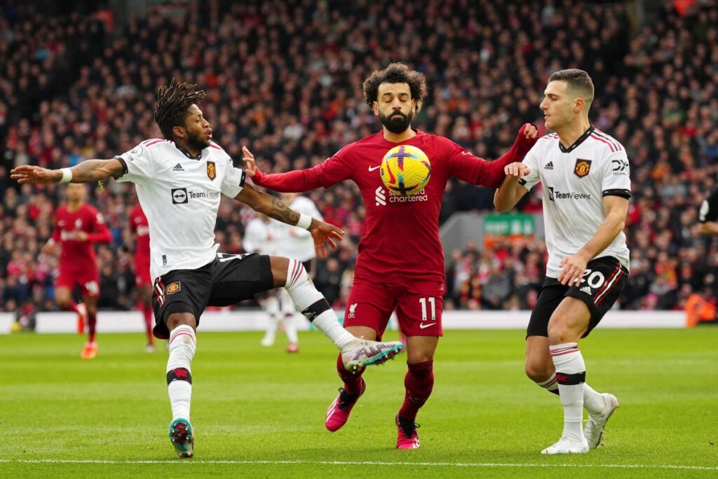 Liverpool's Mohamed Salah, centre, holds off Manchester United's Diogo Dalot, right, and Fred during an English Premier League match at Anfield in Liverpool, England, Sunday. - AP