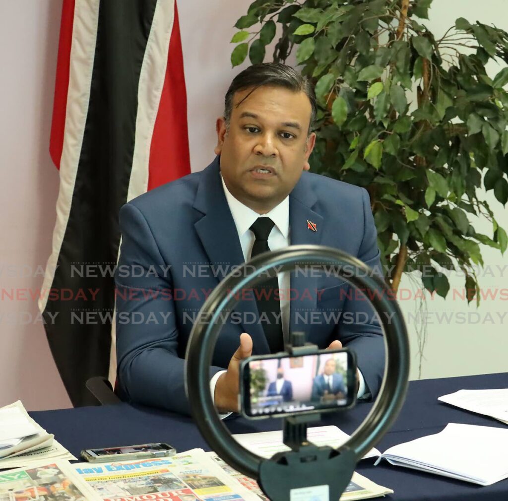 TALKING TO THE PHONE: Caroni East MP Rishad Seecharan looks directly at a cellphne which was recording him as he spoke at the UNC’s weekly Sunday press conference at the Office of the Opposition Leader in Port of Spain. PHOTO BY ROGER JACOB 