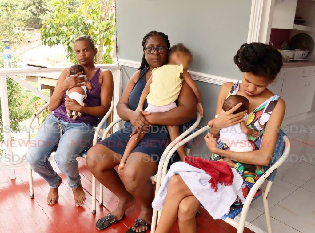 THOSE LEFT BEHIND:
Amy Ramnauth, right, girlfriend of Keston Cumberbatch, and her mother Juliana Ramnauth, left, hold the couple’s 20-day-old twin sons. Keston’s mother Beverly Herry, centre, holds his oldest child (whose face was digitally blurred to protect her identity) in the gallery of the Cumberbatch family’s Mt Hope home on Sunday. Cumberbatch was among two men shot dead on Saturday night not too far from the house. PHOTO BY ROGER JACOB - 
