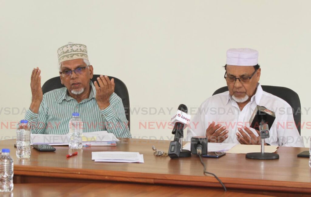 ASJA general secretary Rahimool Hosein, left, and ASJA presient Zainool Sarafat say prayers before the start of a press conference at ASJA's head office in Charlieville on Monday. PHOTO BY ANGELO MARCELLE - 
