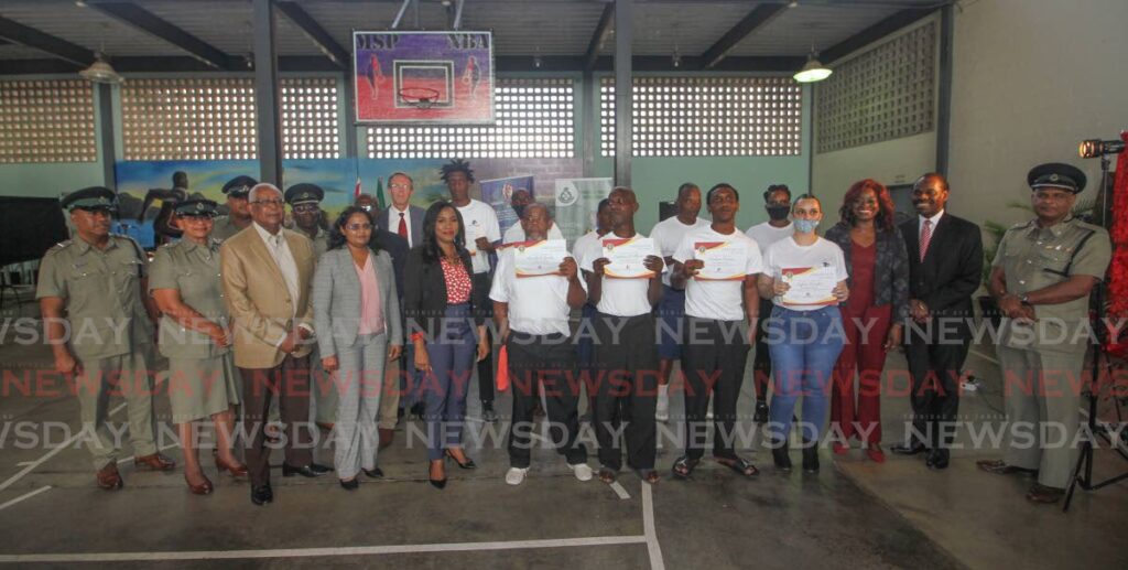 Vision on Mission (VOM) CEO Giselle Chance, fourth from left, Minister of Social Development and Family Service Donna Cox 3rd from right, Minister of National Security Fitzgerald Hinds and Commissioner of Prisons Deopersad Ramoutar on right, with other prison officers, VOM staff and prisoners that participated in the release programme, at the certificate presenting ceremony, Maximum Security Prison, Arouca on Tuesday. - ANGELO MARCELLE