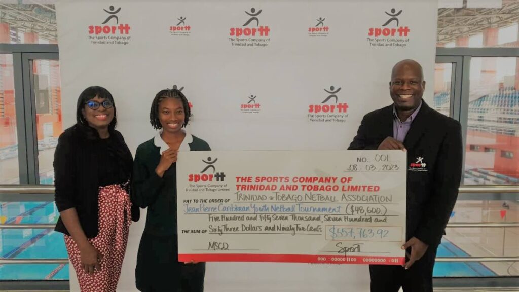 President of the TTNA Sherry Ann Blackburn, left, and captain of the TT Under-16 team Patrice Ashby, receive a cheque from head of sport development at SporTT Justin Latapy-George. - 