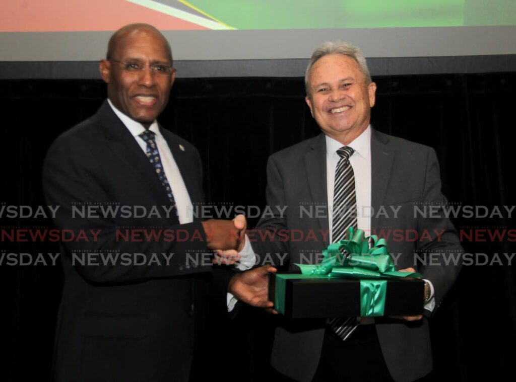 Jamaica's Industry, Investment and Commerce Minister, Senator Aubyn Hill presents a gift to Finance Minister Colm Imbert at the Jamaican Producers Corporation trade mission, Hyatt Regency, Port of Spain on Friday. - AYANNA KINSALE