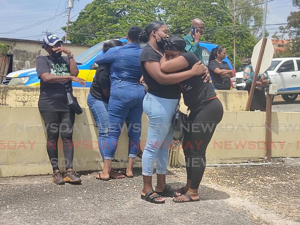 The relatives of murder victom Brandon Victor console each other in the parking lot of the Forensic Science Centre, St James, on Monday morning after identifying his body. 
Victor, was gunned down while at his Cascade workplace last Friday afternoon.  - Photo by Shane Superville