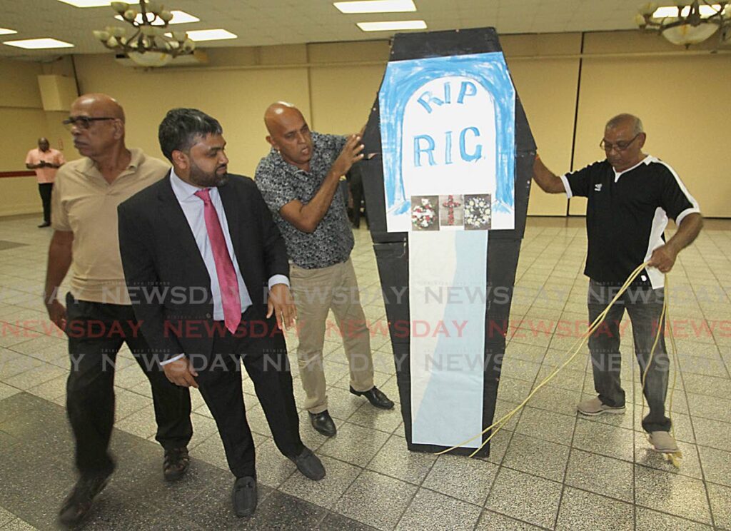 RIP RIC: People display a fake coffin which featured prominently during the RIC's aborted public consultation on Wednesday night at the Centre Point Mall in Chaguanas. FILE PHOTO - 