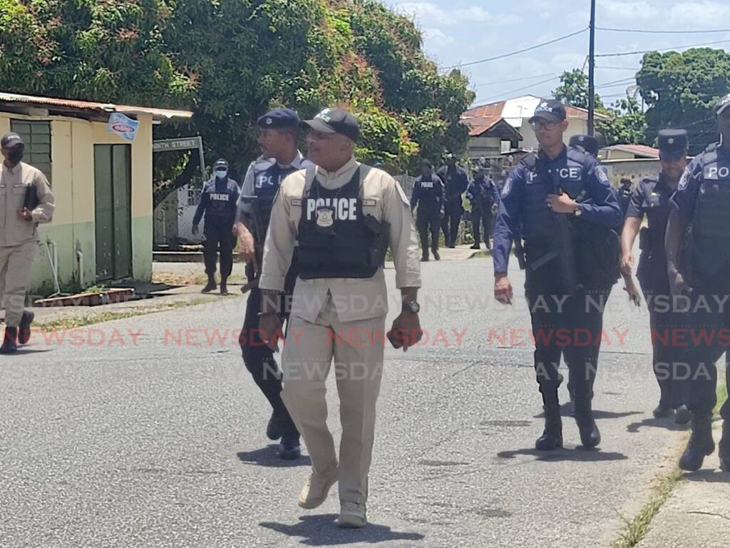 ACP Wayne Mystar leads a team of police on a community walkabout in Five Rivers, Arouca, on Friday. - Shane Superville