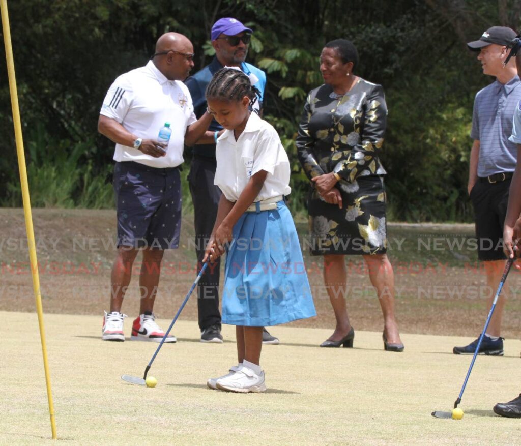  - Nine-year-old Destiny Donald, of the Diego Martin Girls' RC School tries to putt the ball
