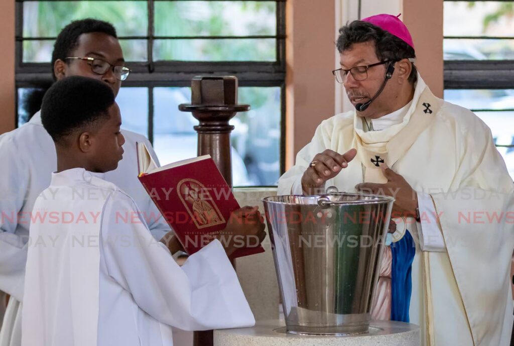 Archbishop Jason Gordon blesses water to sanctify St Joseph RC Church at the consecreation mass.
 - David Reid