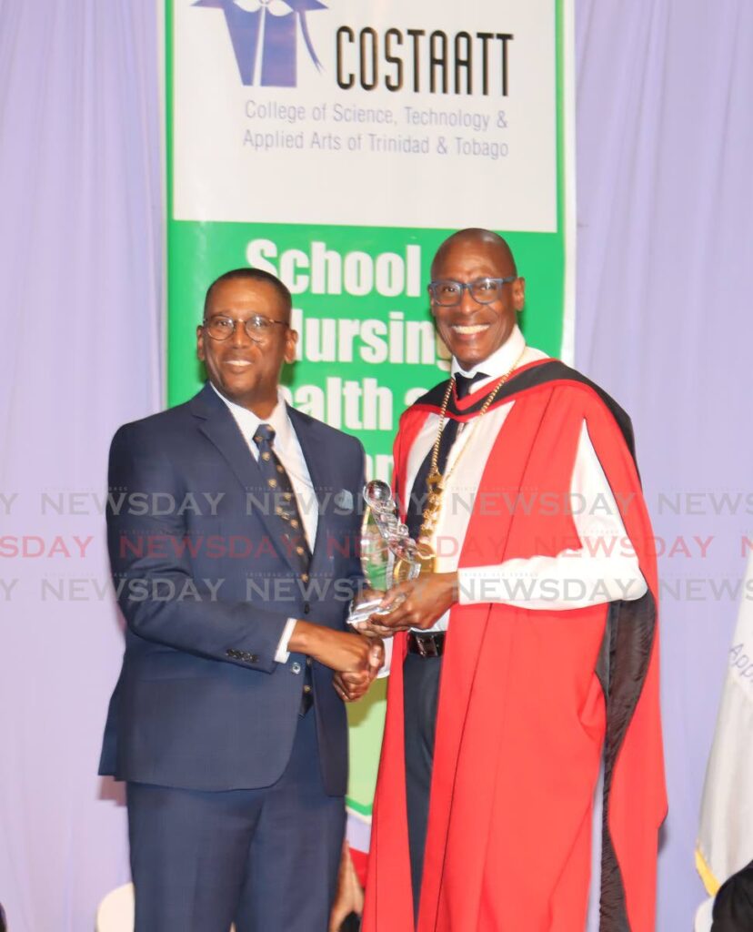 FOR YOU: Chief Justice Ivor Archie, left, receives the Partnership Award from Costaatt president Dr Keith Nurse at the college's graduation ceremony on Saturday at the Centre of Excellence in Macoya. PHOTO BY ROGER JACOB - 