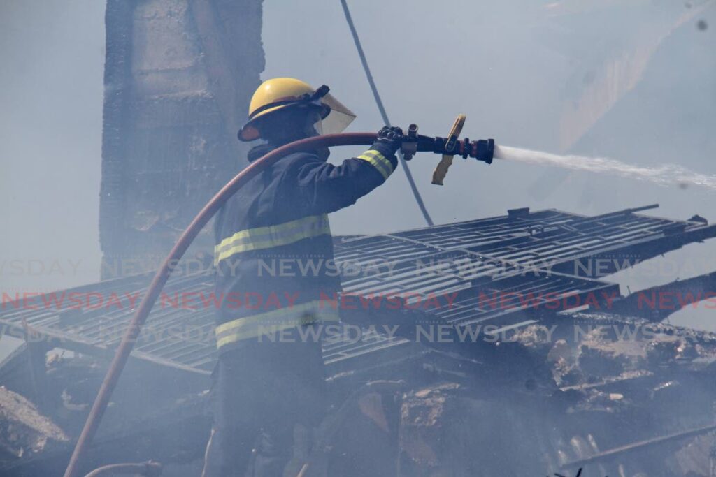 A fireman fights remnants of the blaze. FILE PHOTO BY MARVIN HAMILTON - 