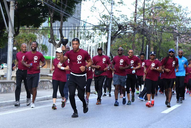 Central Bank's Owen Linton leads their team in the 2019 CariFin Torch Relay on Independence Square, Port of Spain. FILE PHOTO - 