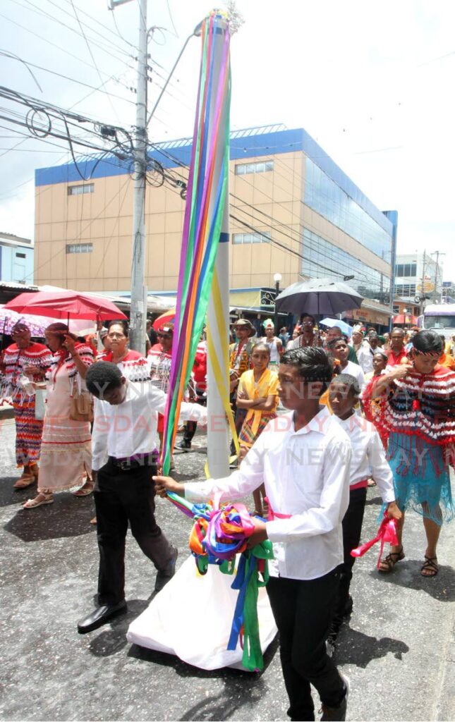 FILE PHOTO: Three boys carry a maypole during a parade in Arima in 2019. - 