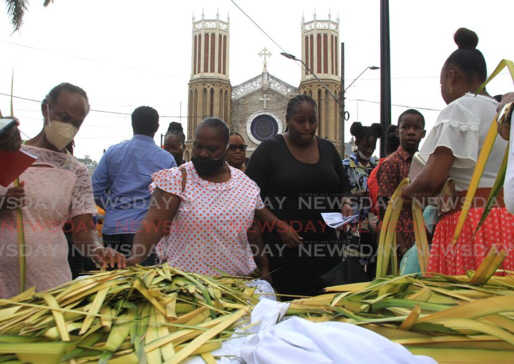 Parishioners gather to take palm fronds outside the Cathedral of the Immaculate Conception in Port of Spain for Palm Sunday. -- Photo by Ayanna Kinsale