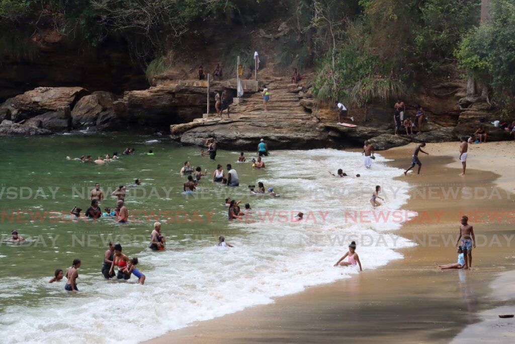 Sea bathers enjoy themselves in the waters of Macqueripe Bay, Chaguaramas, on Easter Sunday. - ROGER JACOB