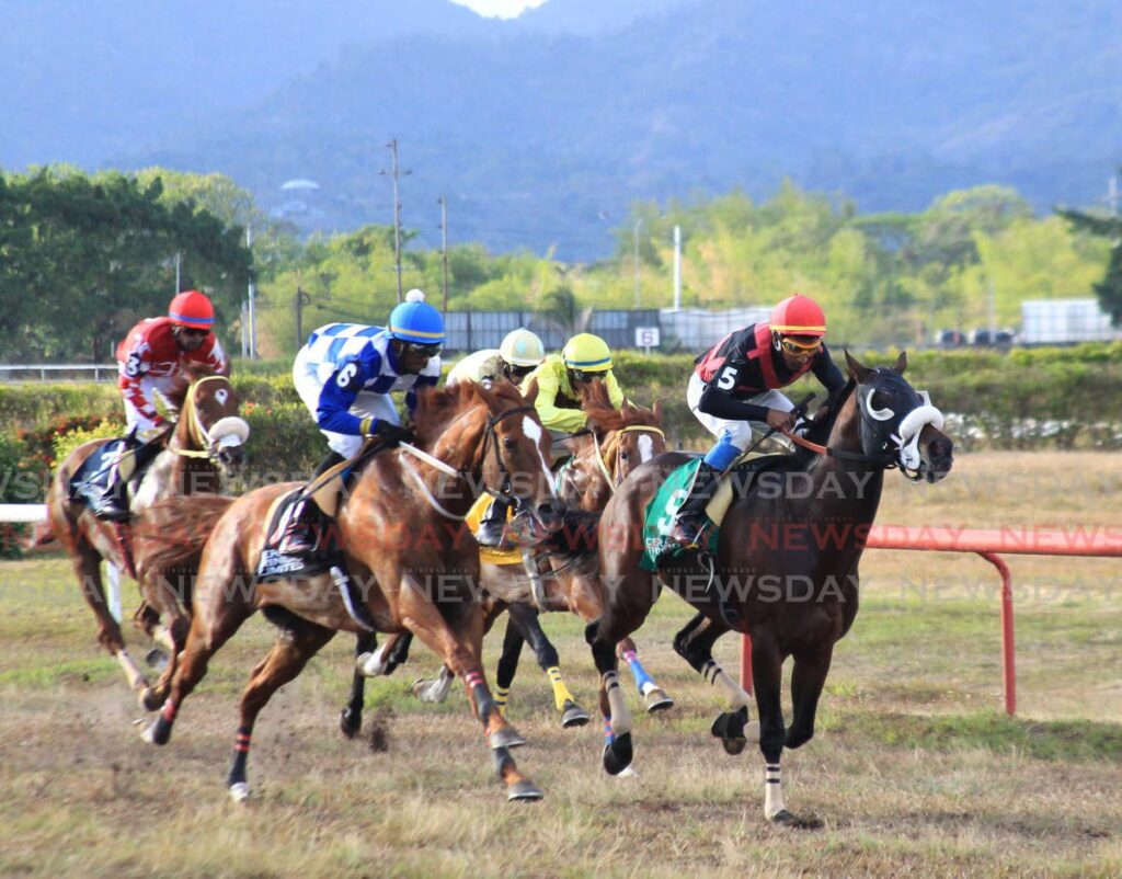 Jockey Andrew Poon takes the lead with Super Bird, right, on his way to victory in the Champagne Stakes at Easter Monday horse racing at Santa Rosa Park, Arima.  - AYANNA KINSALE