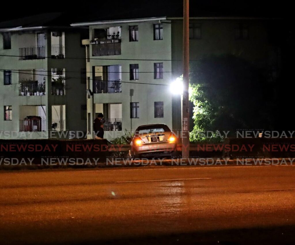 Another view of the car off the highway not too far from the HDC development in Oropune Gardens, Piarco on Monday night. PHOTO BY ROGER JACOB - 