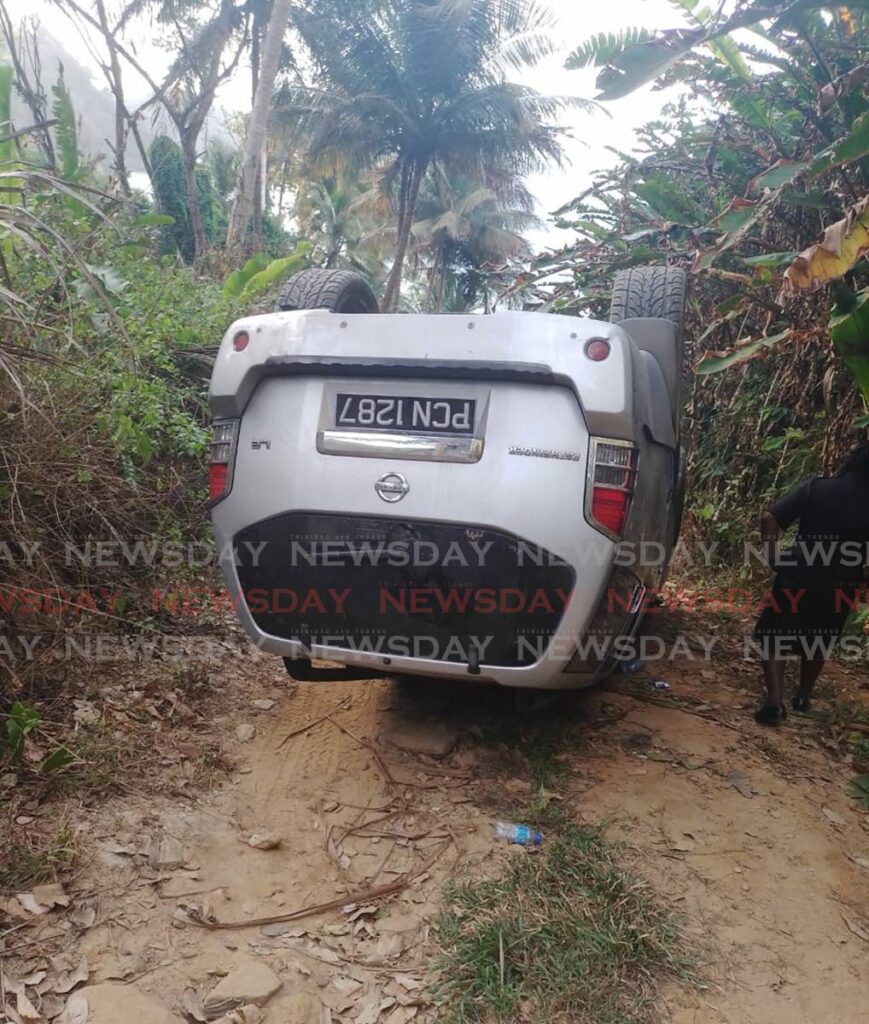 OVERTURNED: The Nissan Pathfinder SUV which overturned after the driver banked it on the side of this narrow, road off the North Coast on Tuesday. - 