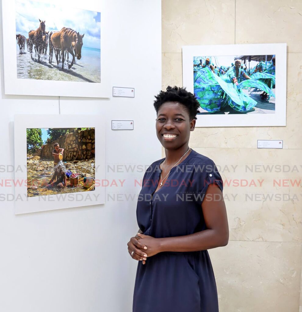 Newsday photograper Ayanna Kinsale stands in front of her three pieces at the Rotunda gallery's Through the Eyes of Women: A tapestry of Trinbago’s Art exhibition. - ROGER JACOB