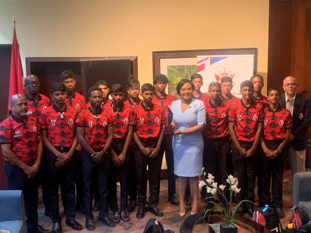 TT Under-15 cricketers and coaching staff pose for a picture with Minister of Sport and Community Development Shamfa Cudjoe at Piarco International Airport on Thursday night. At right is TT Cricket Board president and Cricket West Indies vice-president Azim Bassarath. - TT Cricket Board