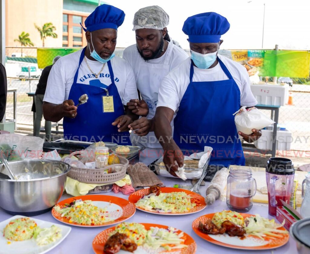 Members of the Team Glen Road United arrange their food before heading to the judges at Tadco's Men Can Cook Competition at Shaw Park Food Hub, Tobago. - Photo by David Reid