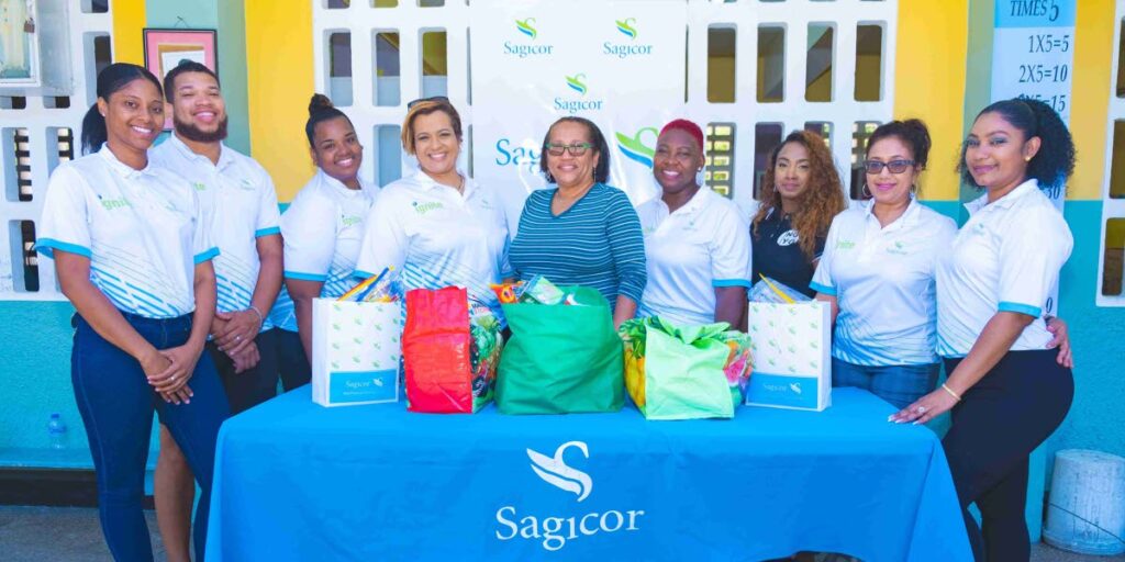 Members of the Sagicor's  Sinanan branch with the principal of Bourg Mulatresse RC Primary School. The branch donated some food hampers for pupils in need. - 