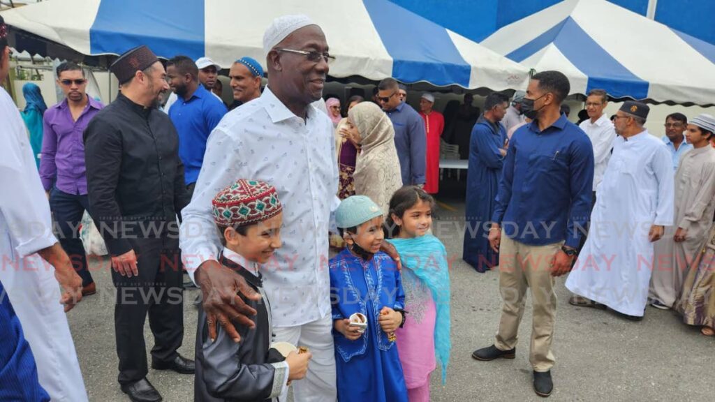 Prime Minister Dr Keith Rowley poses with some children ousdite the Jama Masjid, in San Fernando on Saturday as celebrated Eid-ul-Fitr in 2023.  - Photo by Yvonne Webb