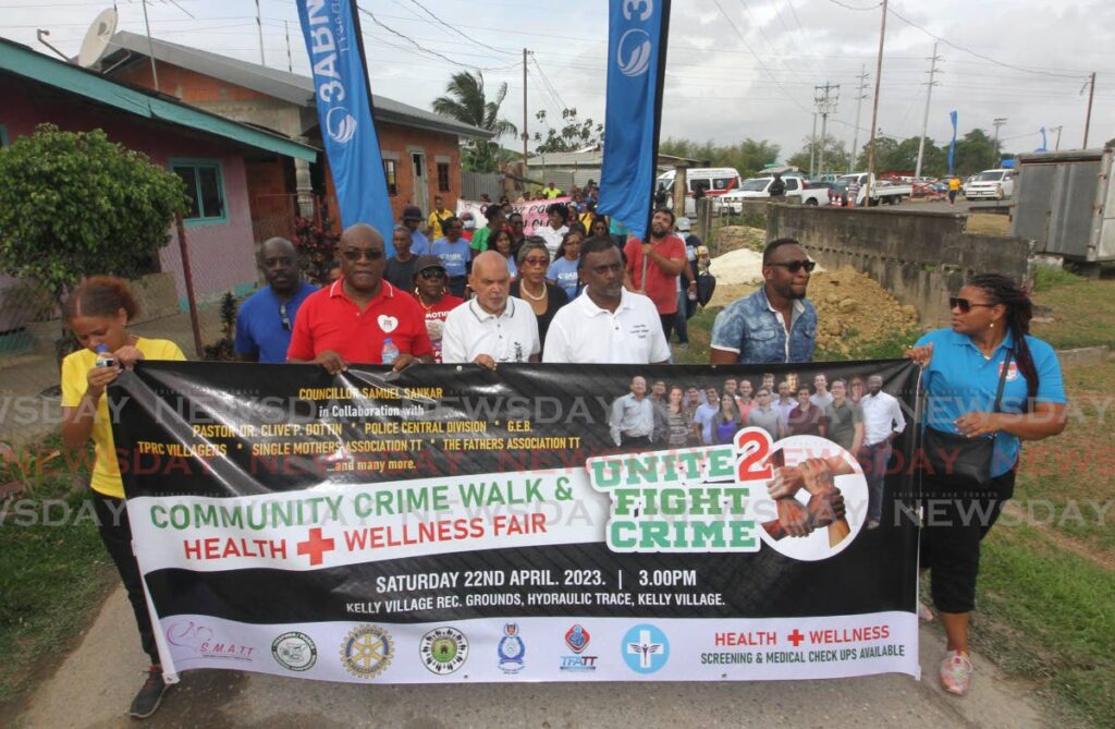 From left front, Dr Oscar Noel Ocho, pastor Clive Dottin, local government councillor Samuel Sankar and Single Fathers' Association president Rondell Feeles, lead the Unite 2 Fight Crime walk from Kelly Village Recreation Ground, Caroni on Saturday.  - Photo by Angelo Marcelle -