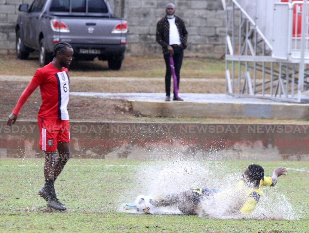 Brandon Semper of Morvant Caledonia AIA, left, avoids a sliding tackle from Cassim Kellar of Defence Forece FC, during their TT Premier Football League match at the Police Training Ground, St James on Sunday.  - ANGELO MARCELLE