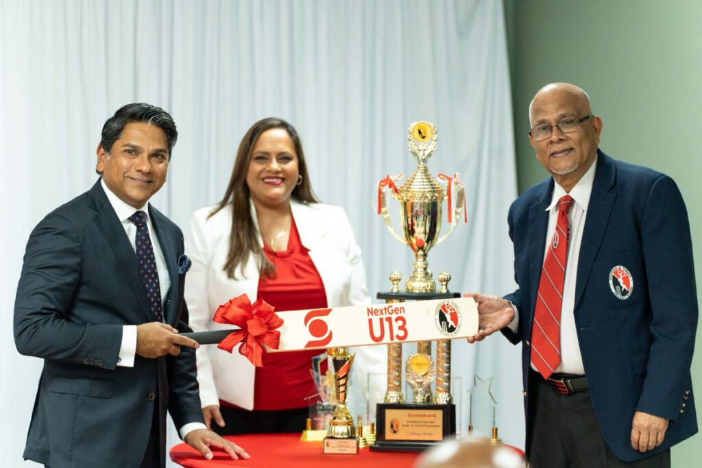 Scotiabank Foundation director Peter Ghany, left, presents TTCB president and recently appointed CWI vice-president with a commemorative bat ahead of Tuesday's start of the Scotiabank NextGen U13 Development Programme. At centre, is Scotiabank's manager of communications and corporate social responsibility, Caribbean south and east. - Scotiabank