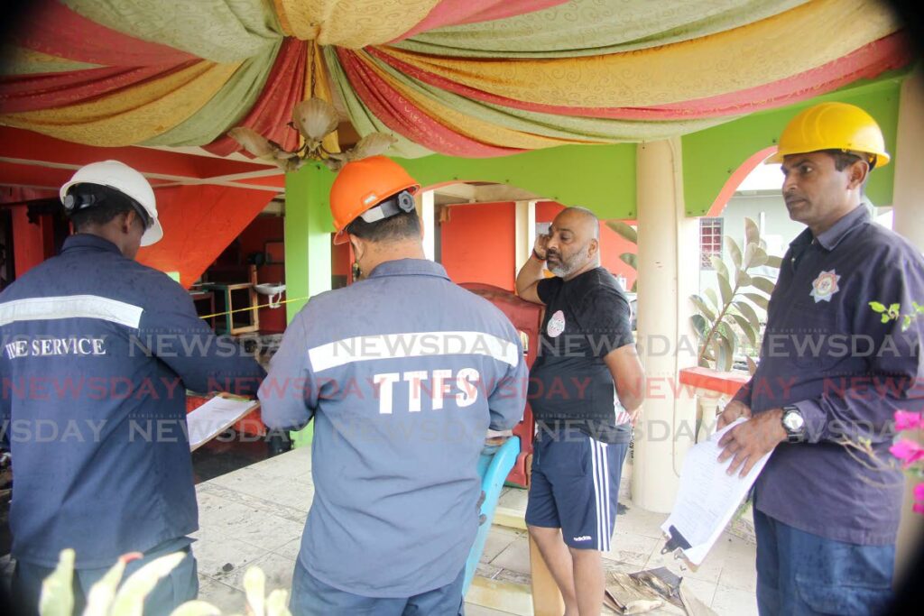 Fire service officials interview Allan Soondar at his Seebalack Branch Trace, Penal, home after it was gutted by fire on Tuesday morning.
