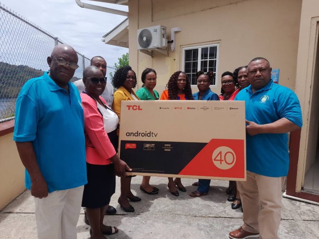 Delaford Tobago Ambassadors president Curtis Nimblett, right, presents a 40-inch television to Delaford RC School principal Ashlyn Melville Cornwall at the school on April 24. Delaford Ambassadors PRO Ansen Blackman is first from left.  - Photo courtesy Delaford Tobago Ambassadors, Trinidad Chapter
