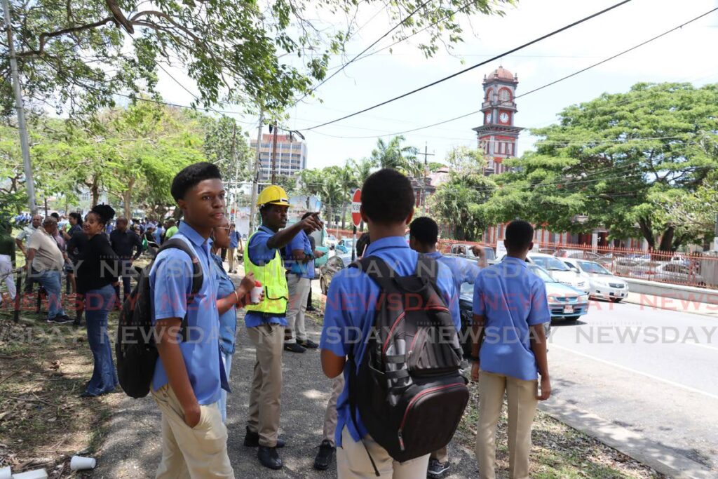 Students from Queens Royal College gather at a muster point at the Queen's Park Savannah after e-mailed bomb threats caused the school to be evacuated on Friday morning. - ROGER JACOB