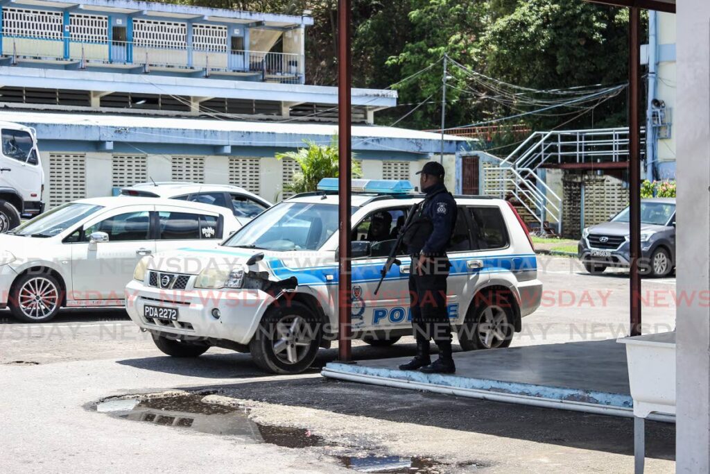 A police officer stands guard on the compound of the Belmont Secondary School, Belmont, Port of Spain, after the school's saftey officer encountered two masked gunmen on the grounds during school hours on Friday morning. - Jeff K Mayers 