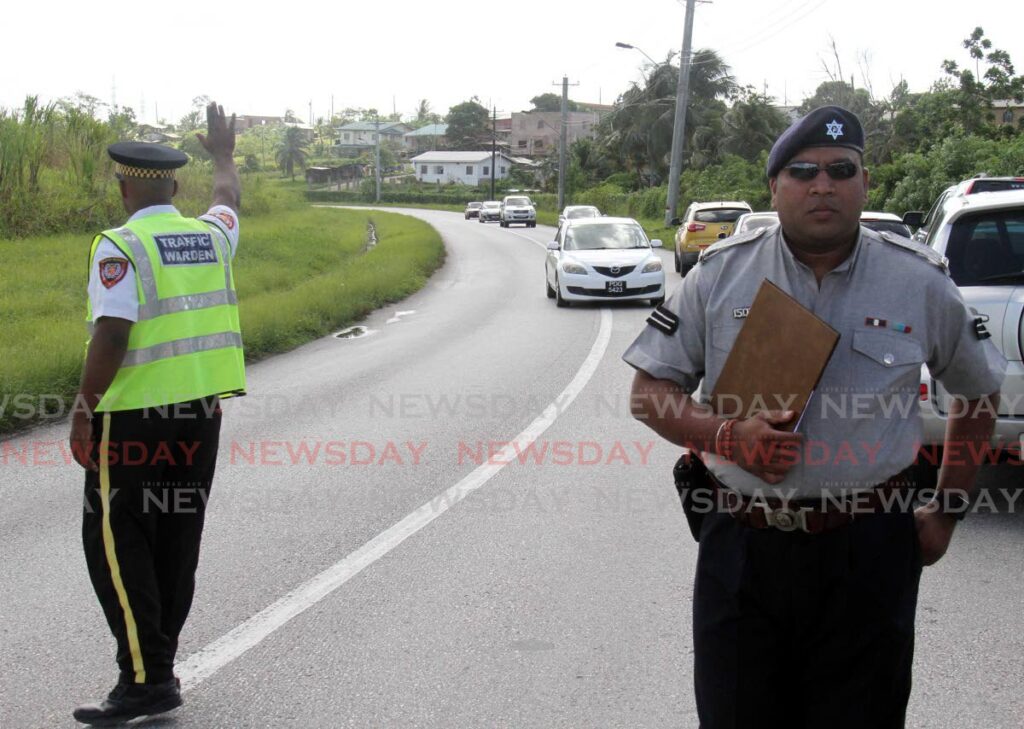 A 2015 file photo of a traffic warden and policeman at M2 Ring Road, Debe, the site of many accidents.  - 