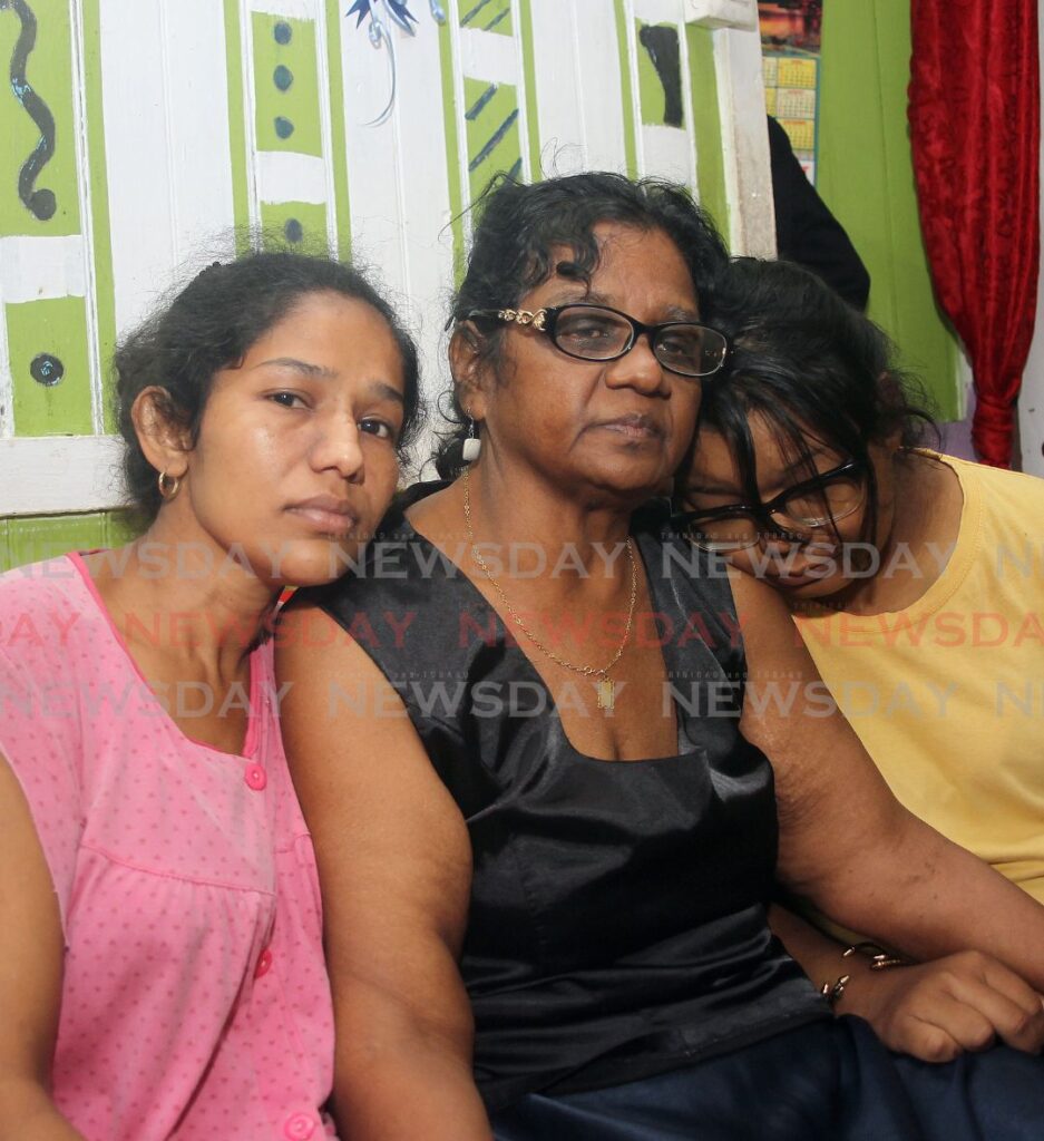 From left:  Parbatee Kumar, wife and mother of Anand and Kishore Kumar, Linda Bhajnath, mother of Anand and grandmother of Kishore,  Kimerley Dean, wife of  Rolly Hosein, the men were executed at their Charlo village Penal home on Tuesday. - Photo by Lincoln Holder