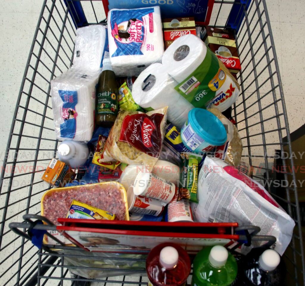 A shopping cart filled with food items and household products. - 