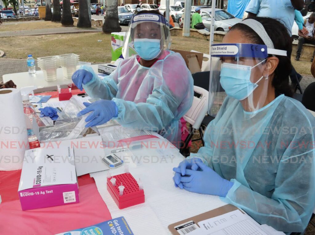 In this February 23 file photo, lab technicians Vanessa Jobe-Home, left, and Leslie Ferdinand prepare to screen people for covid19 at a pop-up lab, Brian Lara Promenade, Port of Spain. The World Health Organization on Friday declared the pandemic is over. - ROGER JACOB