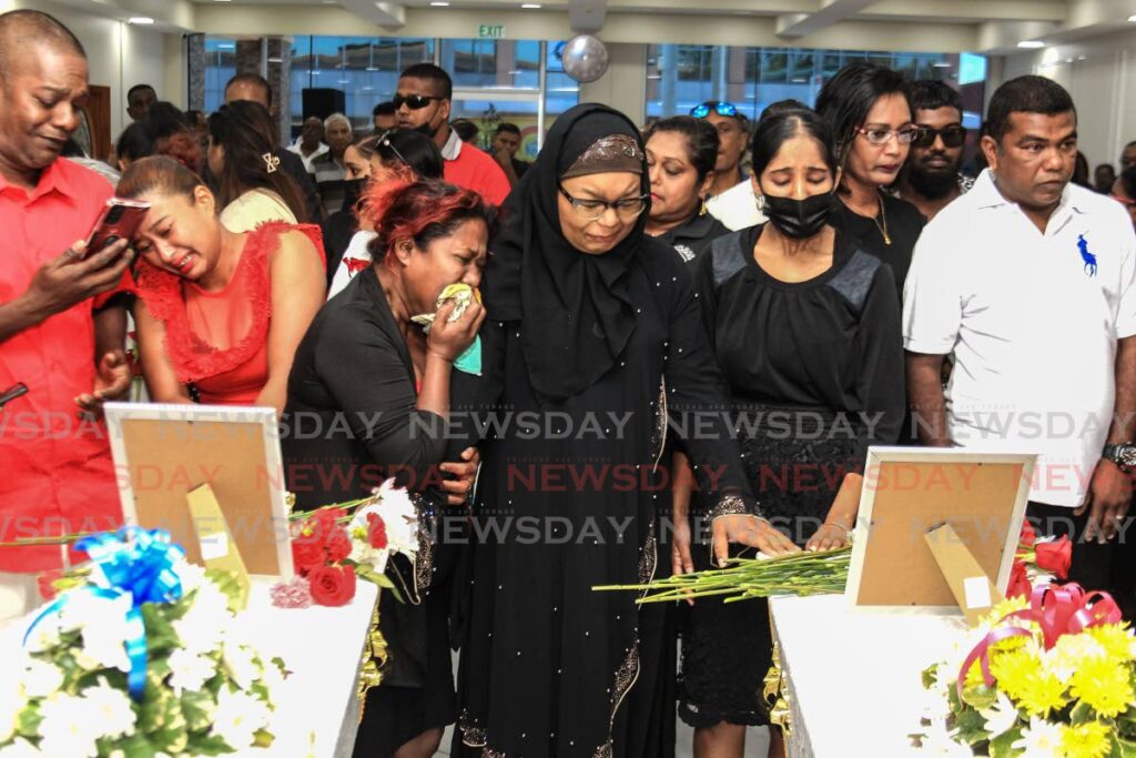 A TIME OF SORROW: Relatives of Anand Kumar and his son Kishore weep during their funeral on Wednesday at Boysie Boodoo's Funeral Home in Penal. The two and Rolly Hosein were gunned down on April 25. PHOTO BY AYANNA KINSALE - AYANNA KINSALE