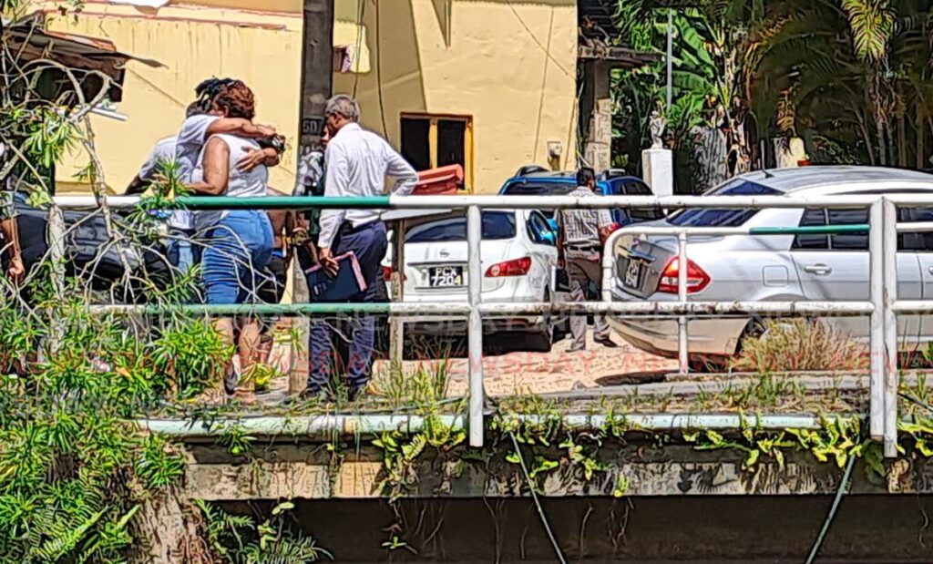 SHOCK AND SORROW: Relatives of murdered Trinidad artiste Antonio Reyes console each other at the scene of his murder in St Ann's on Wednesday. PHOTO BY JENSEN LA VENDE - 