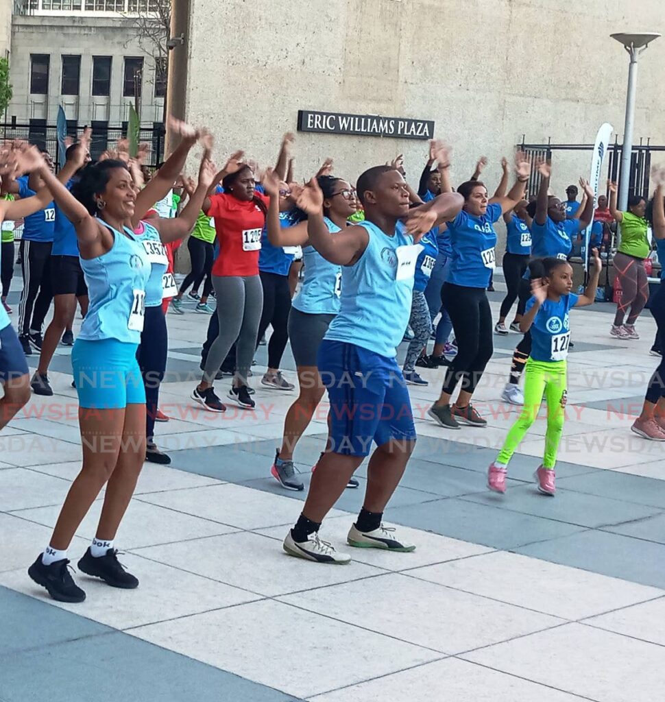 Participants compete in the CariFin Games Aerobics Burnout, including a child, at the Eric Williams Plaza, Central Bank, Port of Spain on Wednesday. - Jelani Beckles