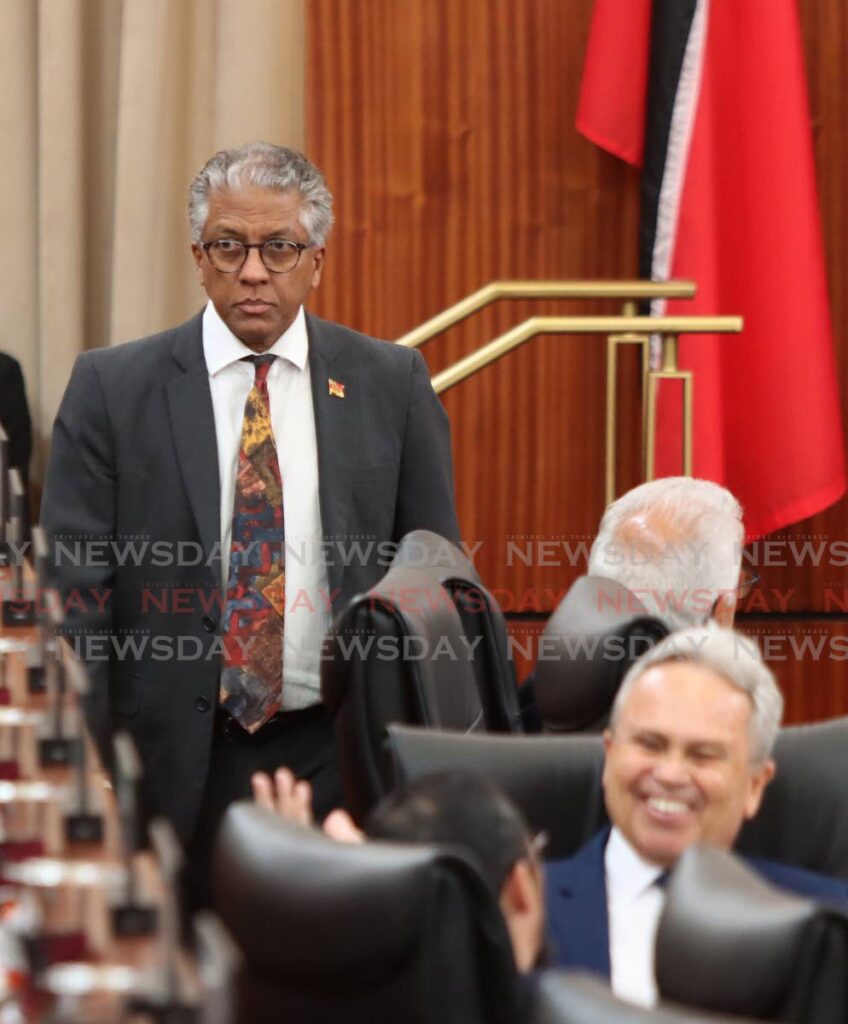 SERIOUS ARMOUR: A serious-looking Attorney General Reginald Armour, SC, enters parliament at the same time Finance Minister Colm Imbert, seated, jokes with Energy Minister Stuart Young on Wednesday. PHOTO BY ROGER JACOB - ROGER JACOB